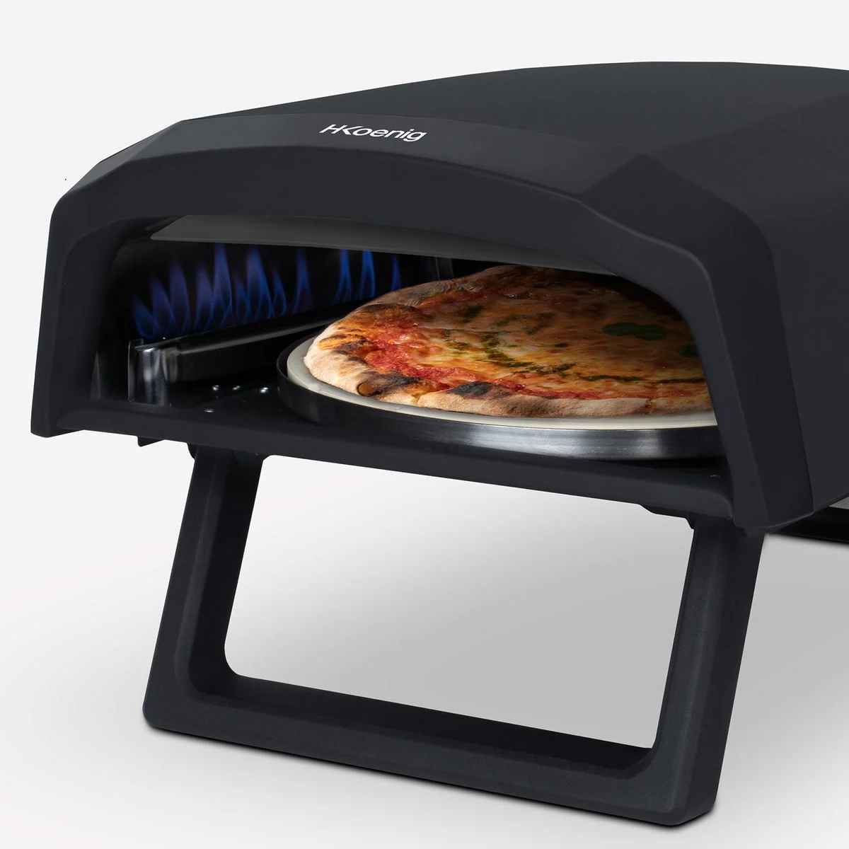 Une pizza en cuisson sur la pierre du H.Koenig GINO640, flammes bleues du brûleur au fond