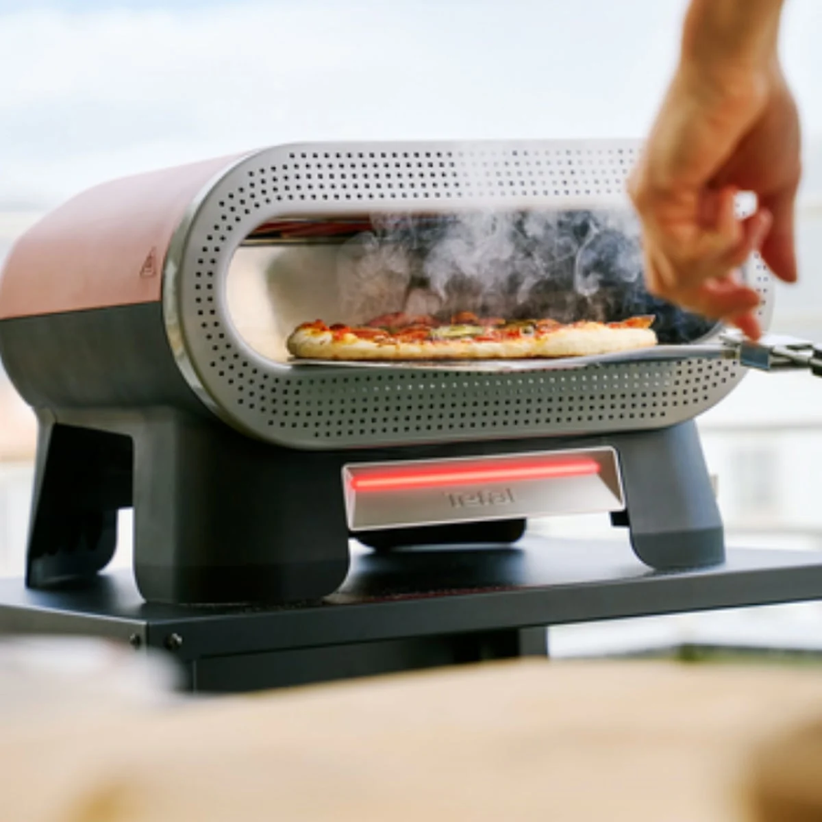 Une pizza en cuisson dans le Tefal Pizza Pronto, en extérieur