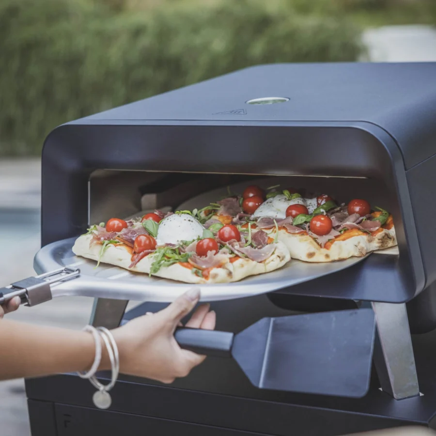 Deux pizzas au jambon cru, tomates cerises et burrata sortent du four Forge Adour Pro sur la pelle