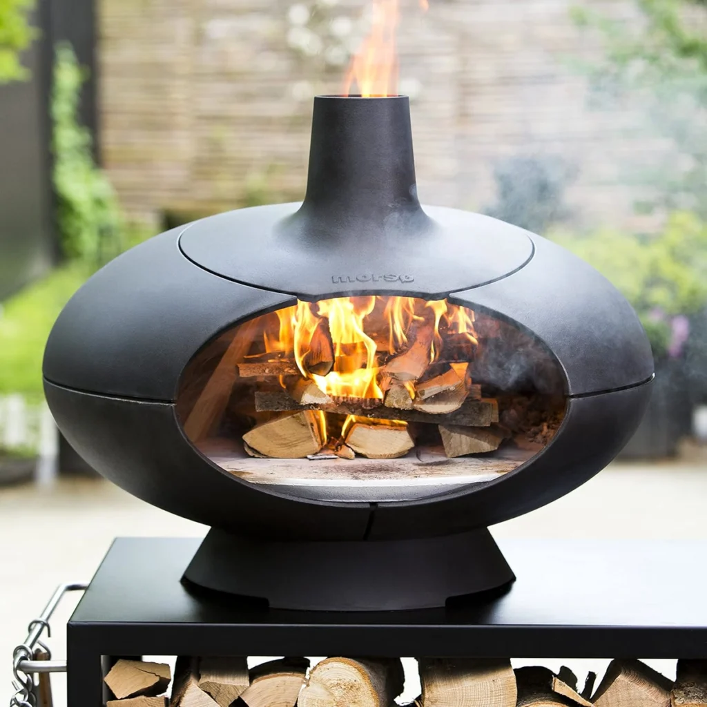 Morsø Forno plein de bûches en flammes, posé sur une table-bûcher (vendue à part)