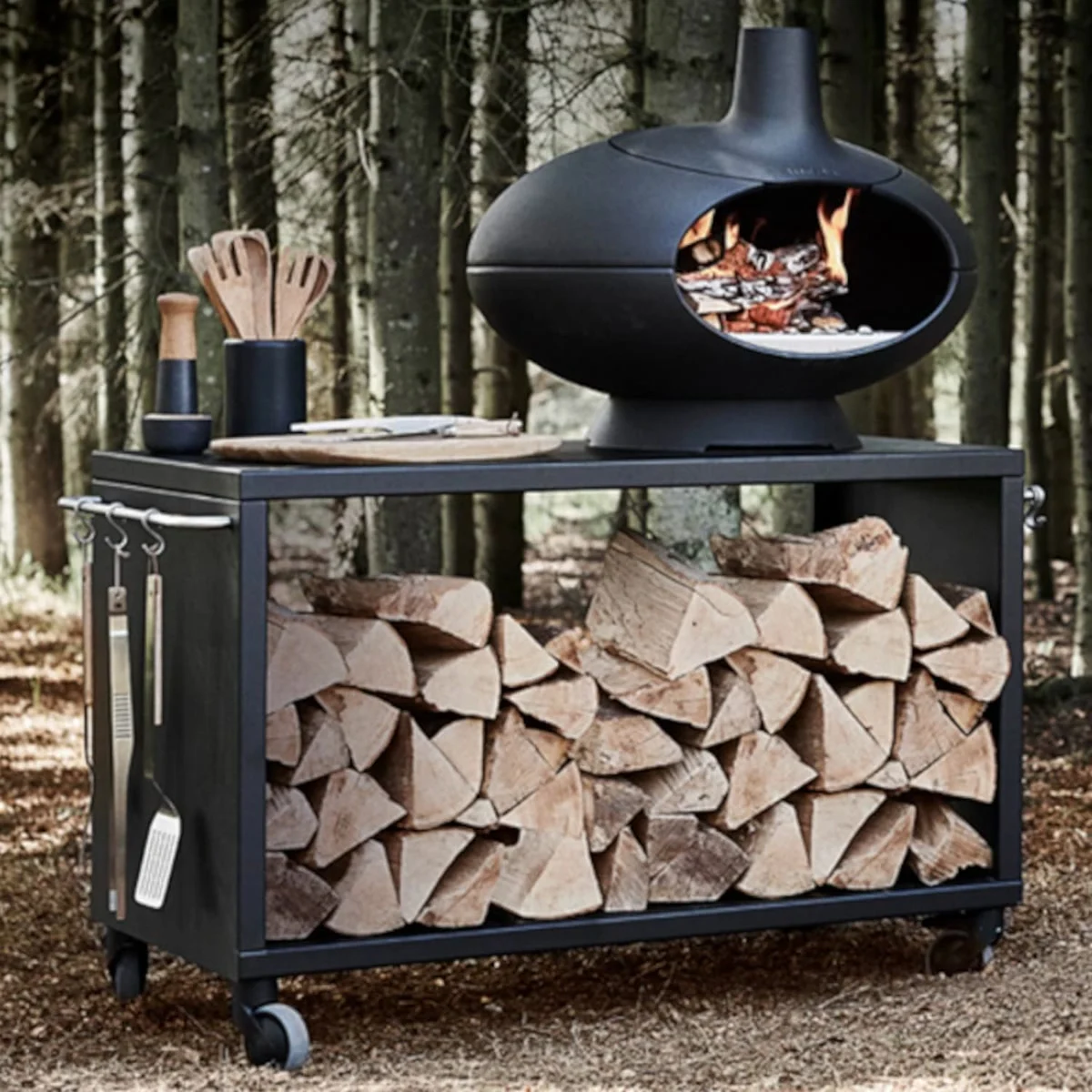 Morsø Forno allumé en sous-bois, sur une table roulante Morsø avec ustensiles (vendus à part)