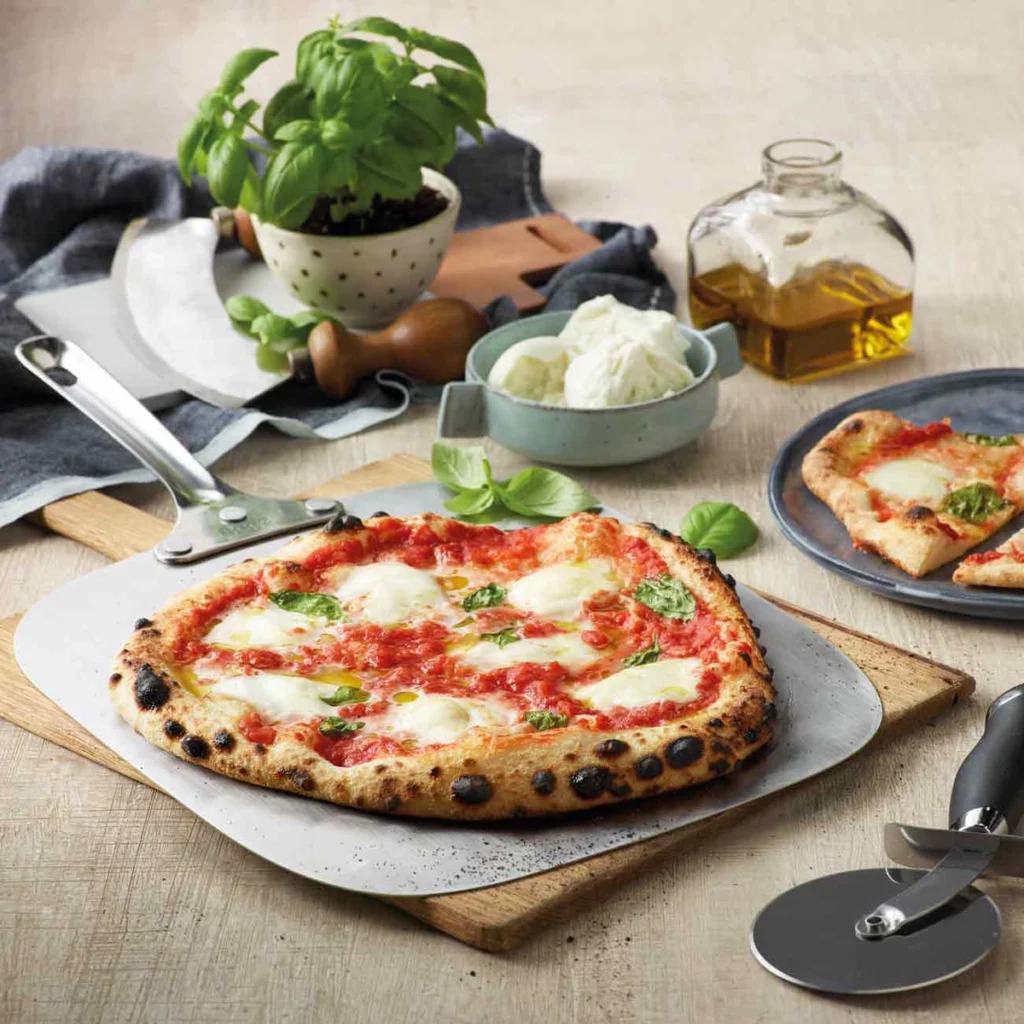 Une pizza margherita sur la pelle du Sage Pizzaiolo, basilic, mozzarella et huile d’olive autour
