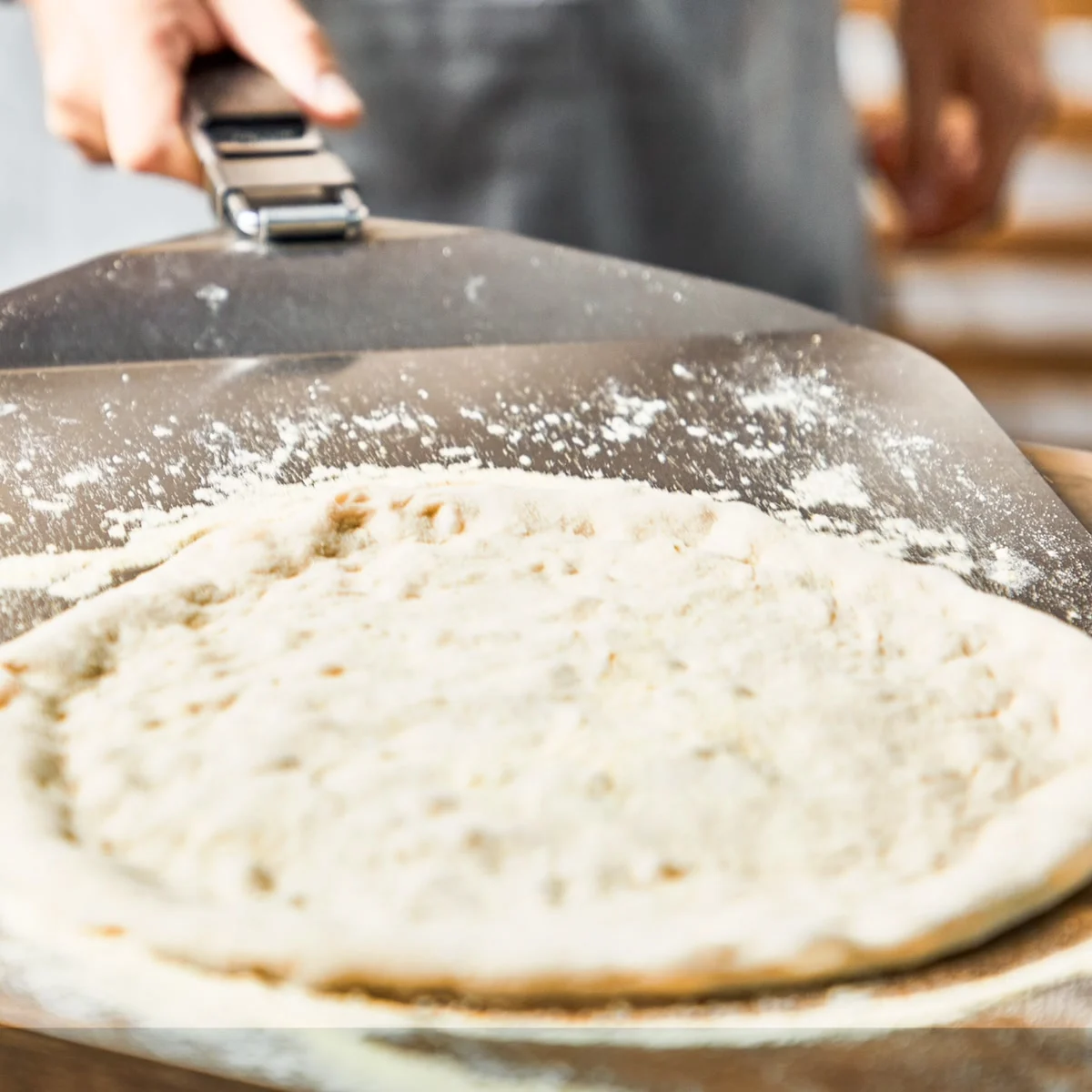 Une pâte à pizza posée sur la pelle fournie avec le Tefal Pizza Pronto Gaz