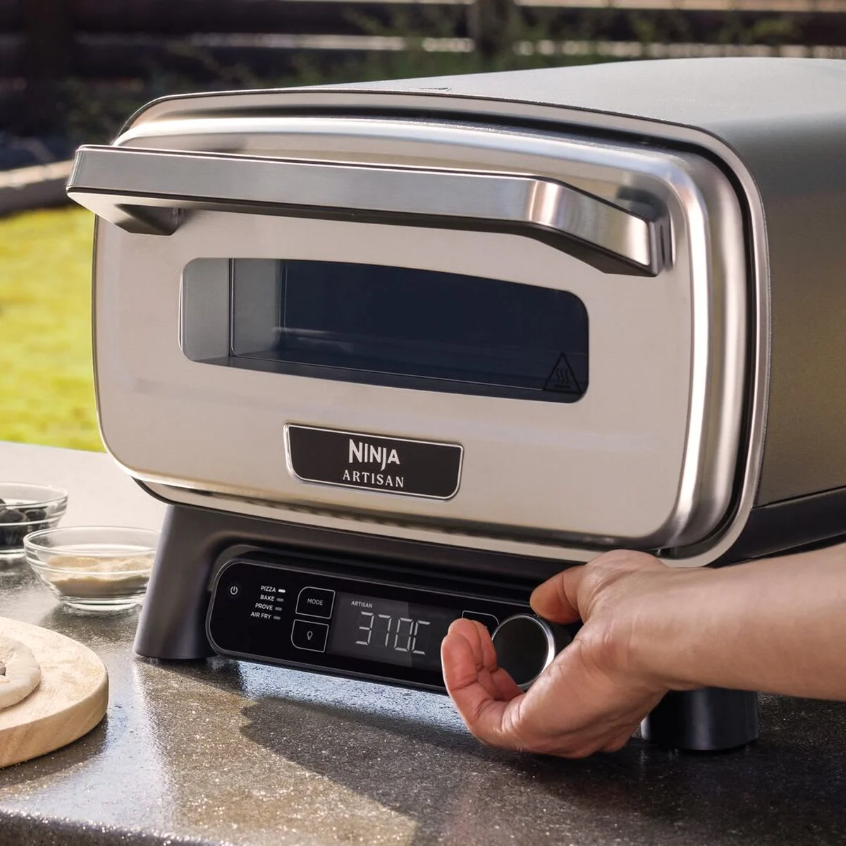 Une main règle la molette du Ninja Artisan, l’écran affiche 370 °C