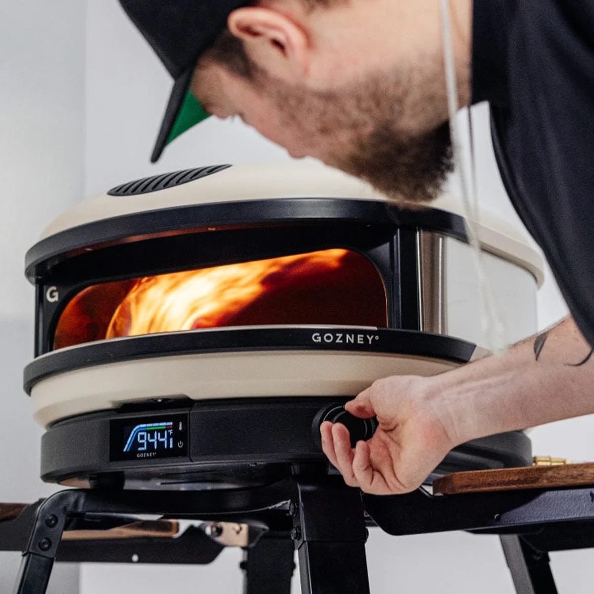 Un pizzaïolo règle la molette du Gozney Arc XL crème, une grande flamme dans le four