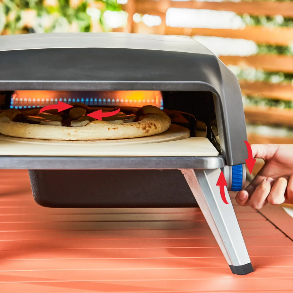 Une main tourne le bouton sur le côté du Tefal Pizza Pronto Gaz : la pierre et la pizza tournent