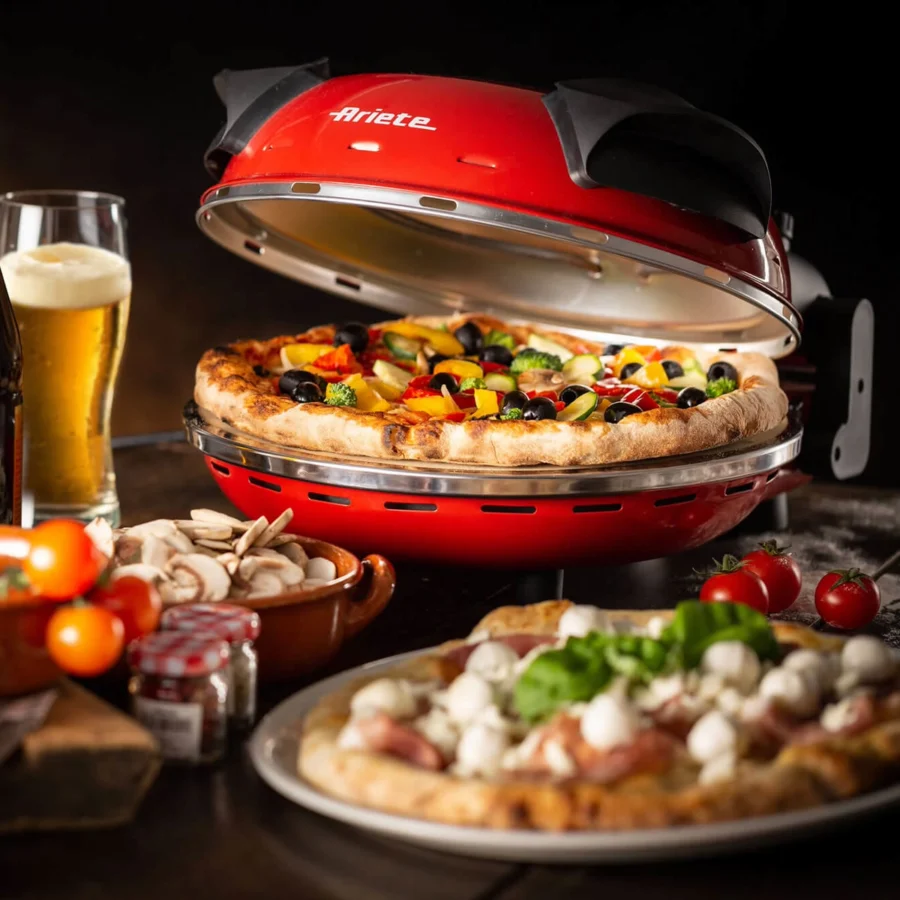 Ariete 909 ouvert sur une table, une pizza aux légumes sur la pierre, une autre pizza devant